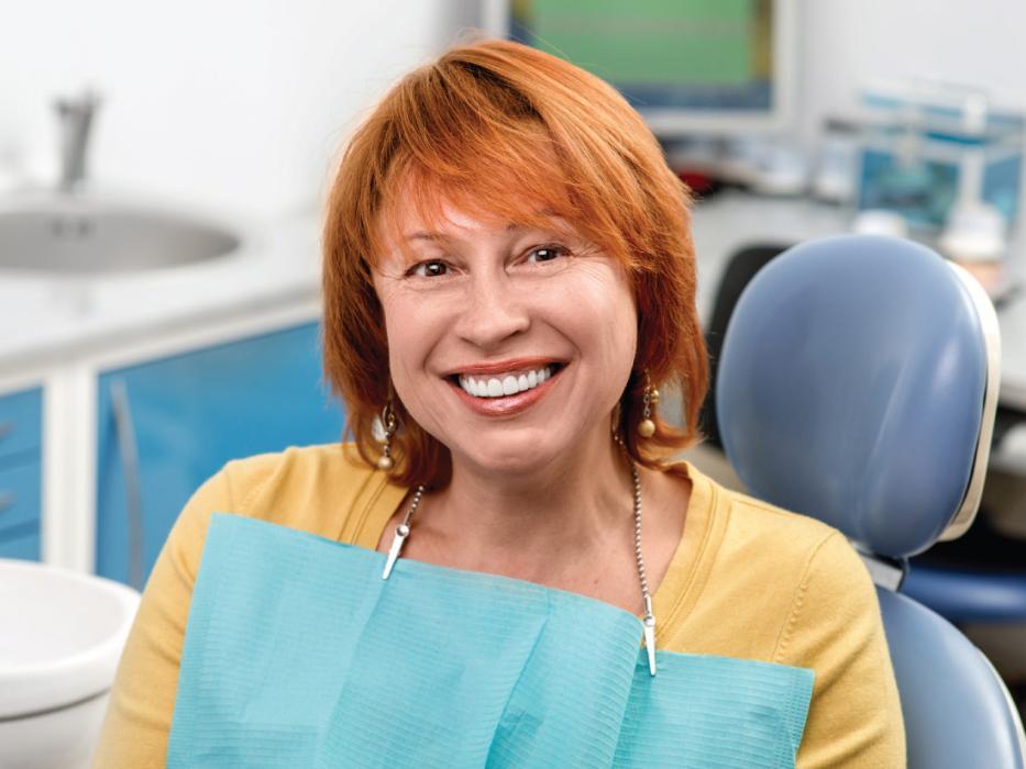 Woman smiling in chair at implant dentist in Lake Forest, CA